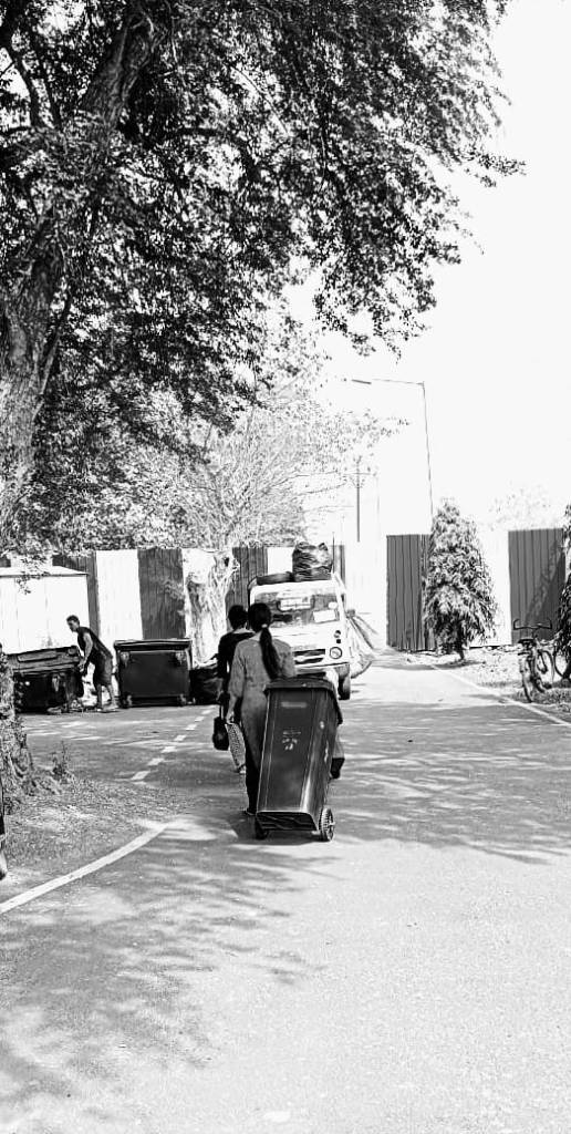 Kavita and her co-worker on their way to unload the dustbins
